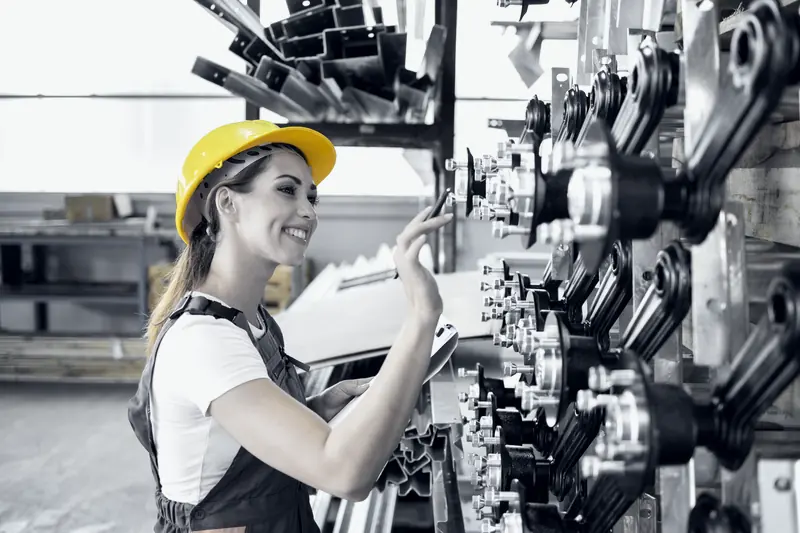 Ingeniera de planta con casco revisando la producción